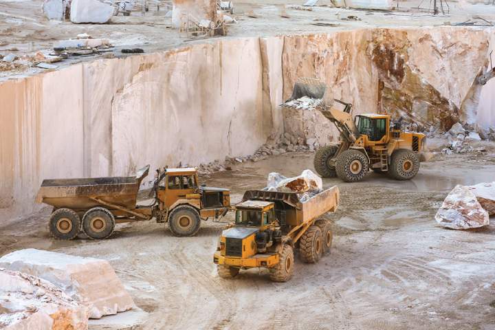 Three dump trucks in a limestone quarry. 